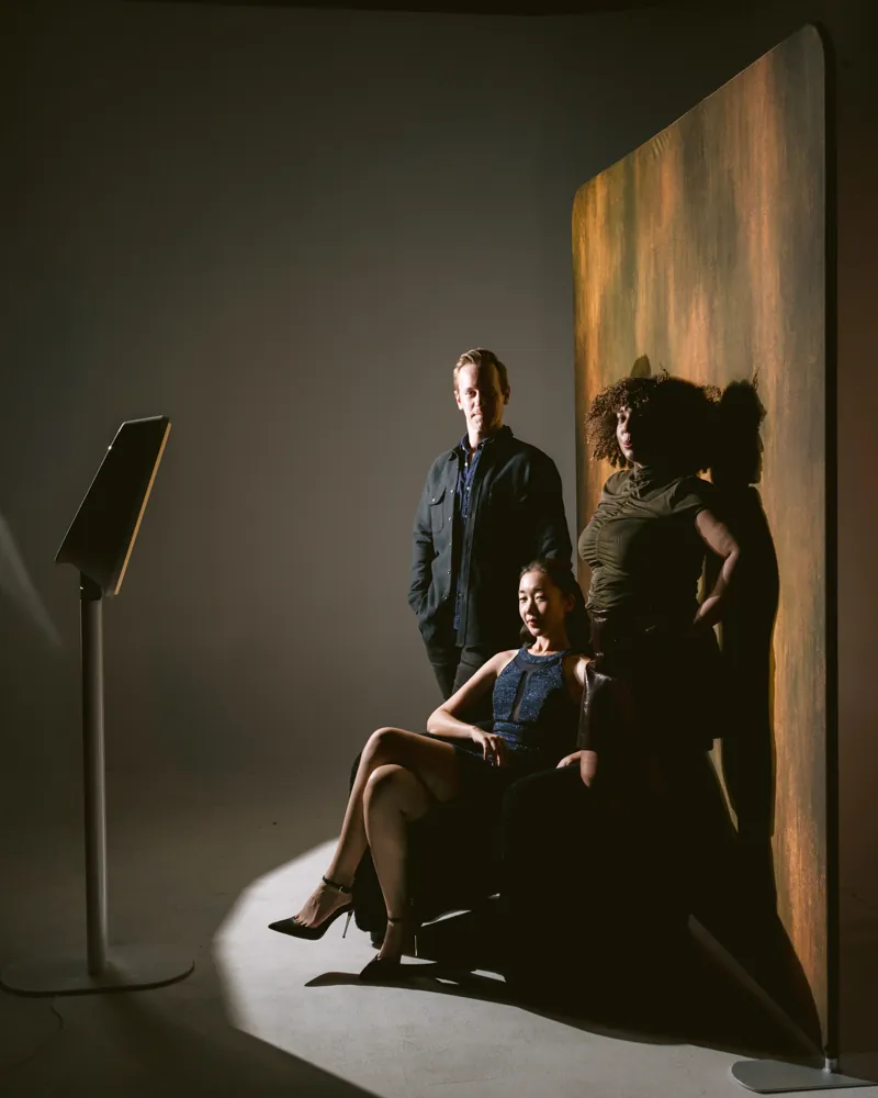 Three guests posing at the AIRi glam booth in dramatic studio light