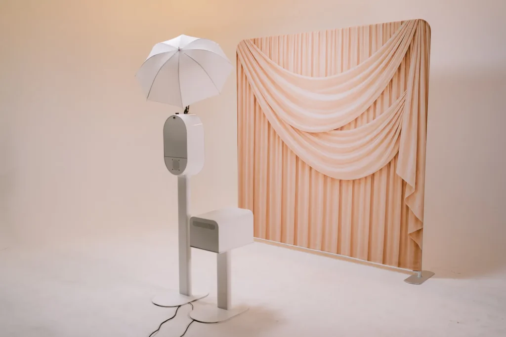 AIRi photo booth with umbrella light and gold drape backdrop