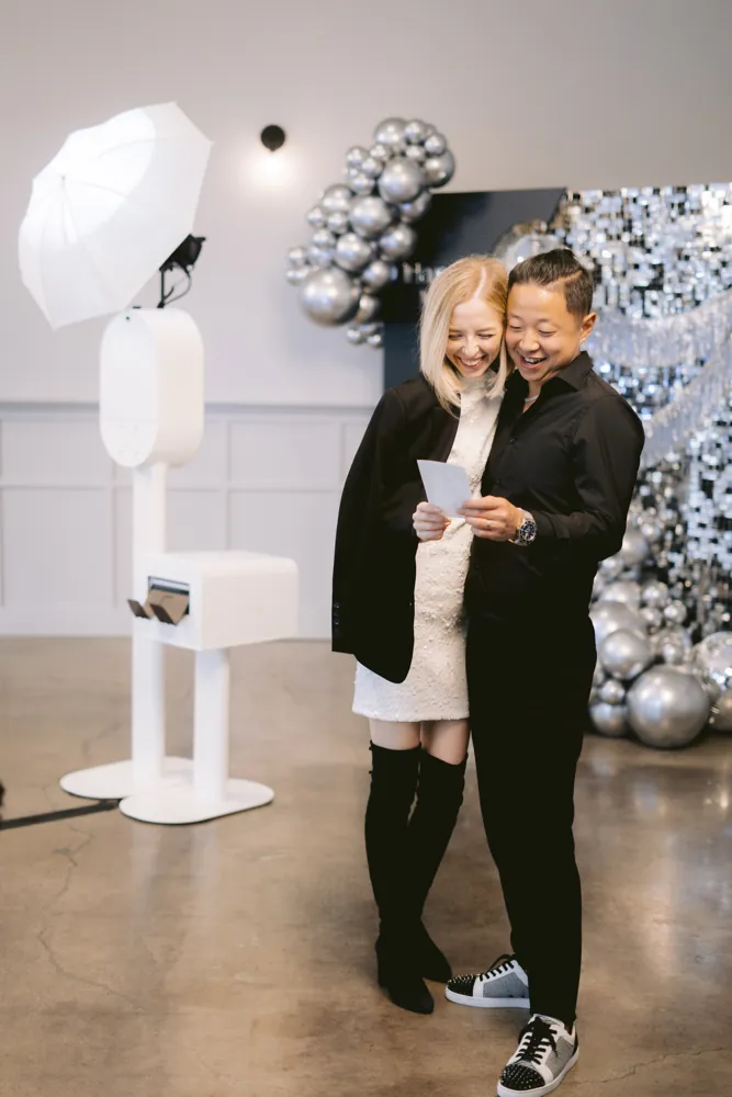 Couple holding their instant print beside the AIRi selfie booth
